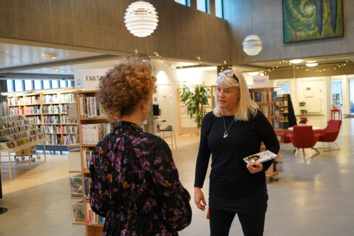 Två personer samtalar inne på Kristianstad Stadsbiblioteket